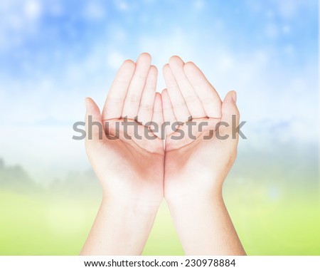 Human open empty hands with palms up, over blurred winter background
