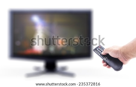 Human hand holding remote and out of focus TV LCD monitor isolated on white.