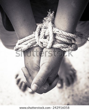 Victim boy with hands tied up with rope in emotional stress and pain, afraid, restricted, trapped, call for help, struggle, terrified.