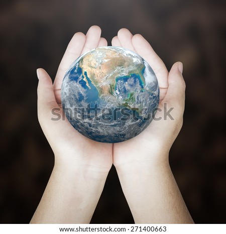 Planet in human hands on blurred nature background. environment concept. Elements of this image furnished by NASA.