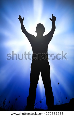 Silhouette human raising hands over blurred amazing beautiful blue sky and clouds background.