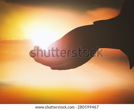 Silhouette hand of God reaching and opening empty hand with palms up over blurred the sunset background. Human open empty hands with palms up. Pray for support concept. Established principle concept.