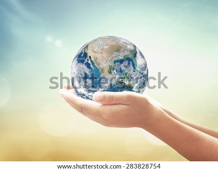 Planet in human hands on blurred beautiful nature background. environment concept. Elements of this image furnished by NASA.