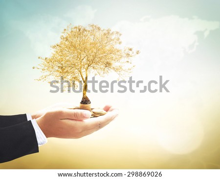 Businessman hands holding golden coins and plant over blurred world map of clouds background. Ecology, Environment, Business, Investment, Seedling in coins, Money coin concept.
