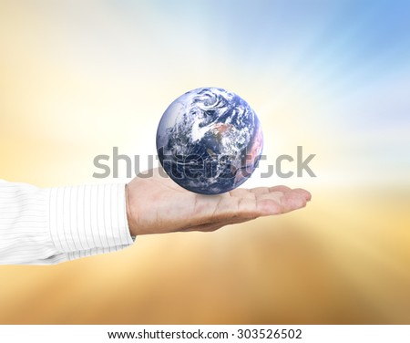 Planet in human hands on blurred beautiful nature background. environment concept. Elements of this image furnished by NASA.