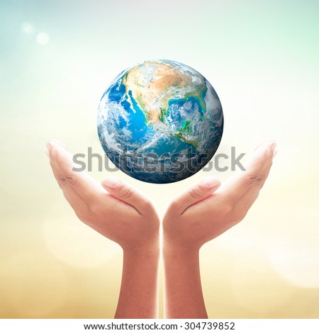 Planet in human hand over blurred nature background. Environment, Earth Day, World Environment Day and Creation from God concept. Elements of this image furnished by NASA.