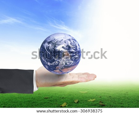 Planet in human hands on beautiful nature background. environment concept. Elements of this image furnished by NASA.