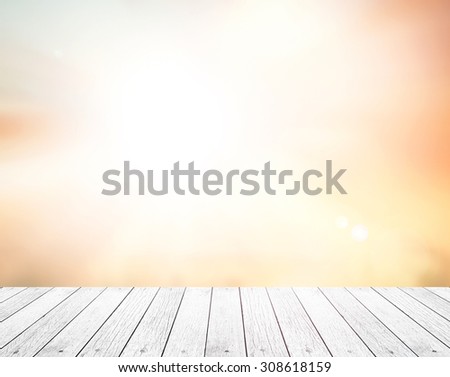 White wooden paving and abstract blurred beautiful sunset background: yellow and orange patterns.