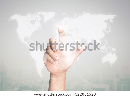 Human hand touching on world map with futuristic communication interface on blurred the city. Elements of this image are furnished by NASA.