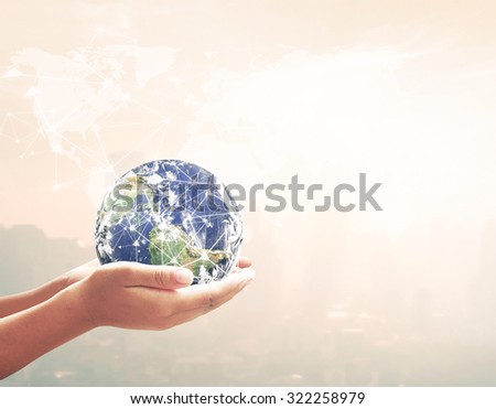 Close up of human hand showing planet over blurred world map of clouds over the city sunset background. Elements of this image furnished by NASA.