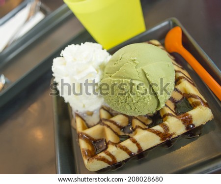 green tea ice cream on the table with waffle and whipped cream