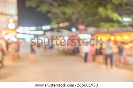image of blurred background night market on street decorated with festive lights.