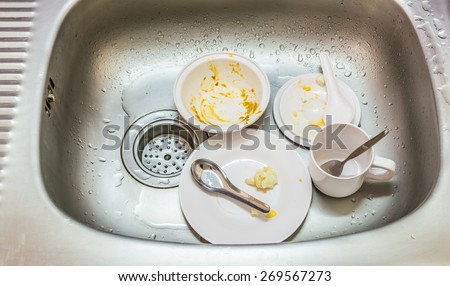 Kitchen conceptual image. Dirty sink with many dirty dishes and kitchenware.