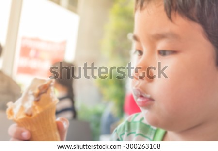 blur image of happy boy eating ice cream on day time with ice cream dirty on his mouth