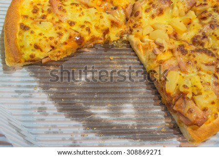 image of Deep-pan pineapple with ham Pizza with a slice missing.