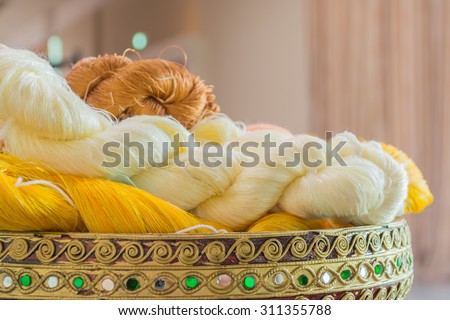 image of colorful thai silk roll on antique wooden tray.