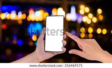 male hand is holding a modern touch screen phone and blurred bokeh background with warm orange lights (blurred)