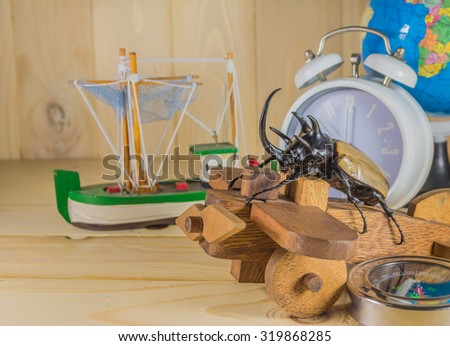 image of five horn beetle and wooden plane on  pine wood table background.(selective focus on beetle)