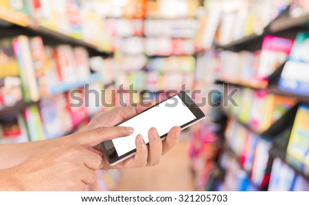 male hand is holding a modern touch screen phone and blurred image of book store for background usage .