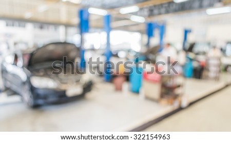 blur image of worker fixing car in ther garage for background usage.