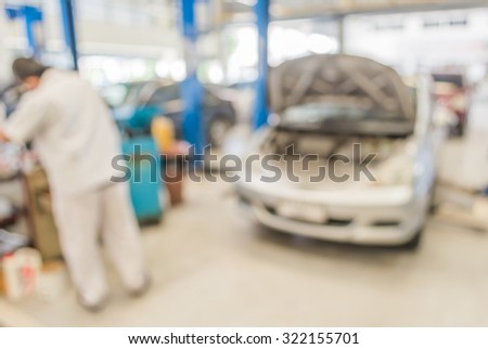blur image of worker fixing car in ther garage for background usage.