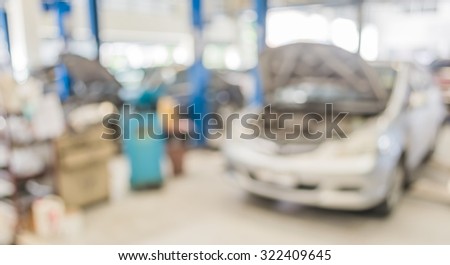 blur image of worker fixing car in the garage for background usage.