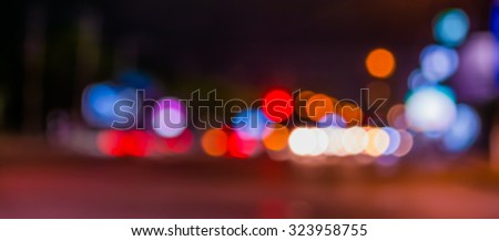 image of blur street and billboard with warm colorful lights in night time for background usage .