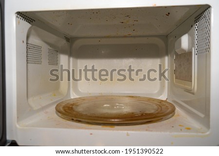 Dirty microwave. The inside of the microwave is covered with traces of cooking grease