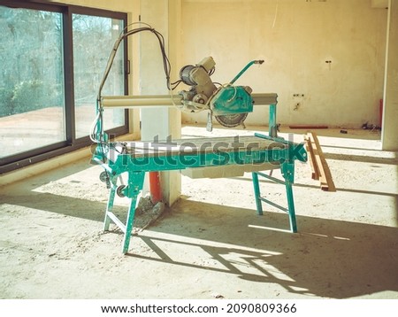 Tiling and laying of marble and porcelain stoneware concept. Wet saw cutting tile machine. Large Circular saw with bathtub for liquid. Tile Production Workshop. Foto stock © 