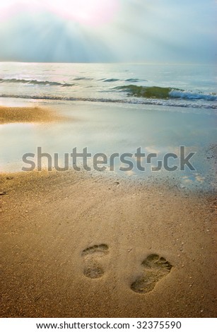 Footprints on the beach at sunset with soft light
