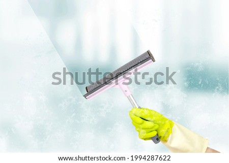 Washing windows theme. Window cleaner using a squeegee to wash a windows. Spring cleaning concept. Window cleaning brush for windows washing
