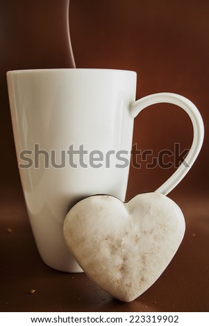 Cup mug white big hot baking gingerbread cookies on a brown background