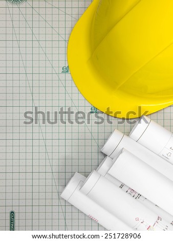 Architectural blueprint of office building with a Safety hat on cutting mat