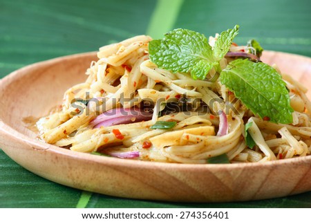 Thai bamboo shoot spicy salad served in wooden plate on banana leaf