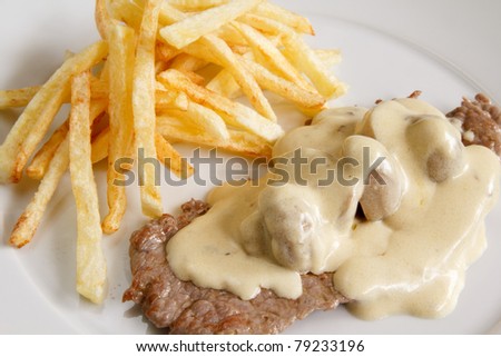 Beef and french fries with mushrooms and cream sauce