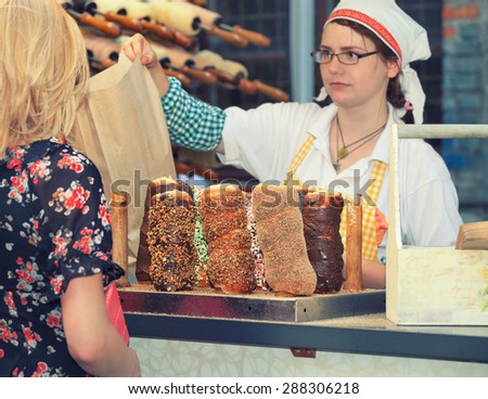 Budapest, Hungary - December 2013: Hungarian woman selling traditional chimney cakes