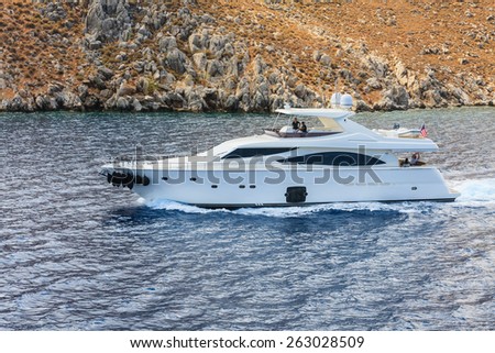RHODES ISLAND. GREECE - AUGUST 02, 2014: Yacht near rocky shore of  Rhodes Island on August 02, 2014. Greek islands are popular tourist destination for many Europeans.