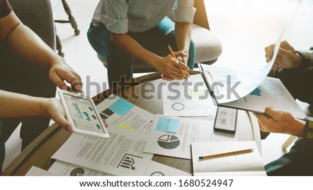 Photo of Business people meeting at office writing memos on sticky notes. planning strategy and brainstorming, colleagues thinking concept