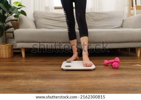 Healthy and weight loss concept, Young Asian woman stepping on weighing scales after weight control. Сток-фото © 