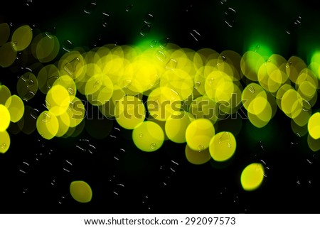 Image of raindrops on window at night in the city.