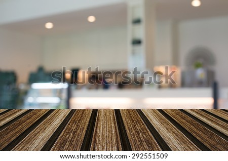 Selected focus empty brown wooden table and Coffee shop blur background with bokeh image for your photomontage or product display.