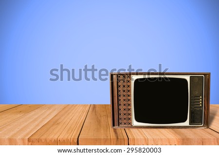 Old Style Photo. Classic vintage and retro TV on the table with blue wall background