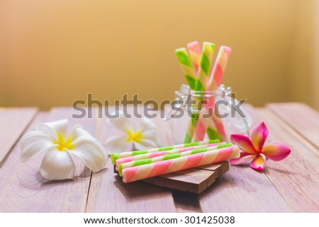 Wafer roll sticks glass bottle and wooden table