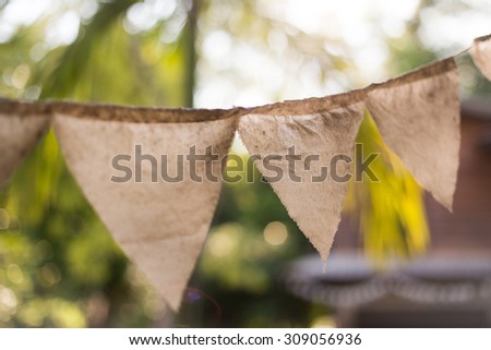 Colorful bunting flags hanging on tree with retro filter effect