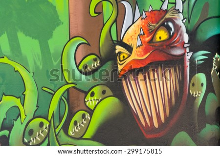 BORDEAUX, FRANCE - June 23, 2015: Graffiti art forest plant monsters with big teeth on a fence in the city suburbs