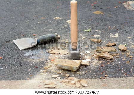 Bricklayers bolster chisel and lump hammer on floor