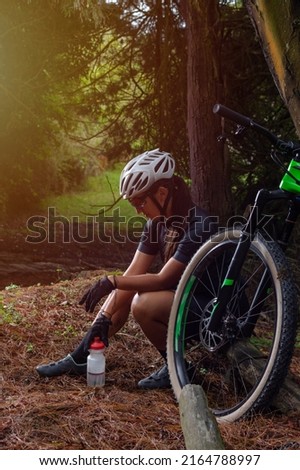 Similar – Foto Bild Mountainbiker aufgestützt auf Fahrradlenker blickt in die Ferne.