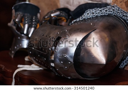 knight\'s helmet with visor and gloves on the table