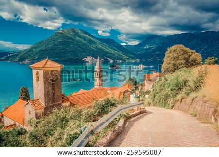 Harbor and ancient buildings in sunny day at Boka Kotor bay (Boka Kotorska), Montenegro, Europe. Retro toned image.