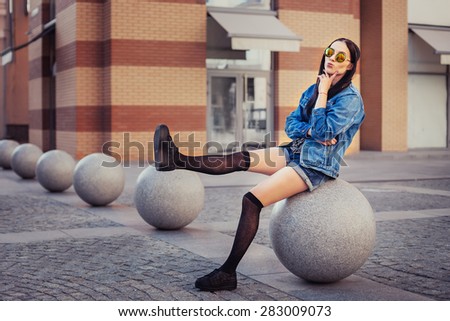 Outdoor lifestyle portrait of pretty young girl, wearing in hipster swag grunge style urban background. Retro vintage toned image, film simulation.